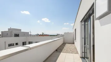 Sonnige Dachterrasse mit Fliesen und Kies, bietet einen weiten Blick in die Ferne.