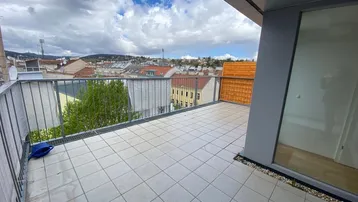 Große geflieste Terrasse mit Metallgeländer und weitem Blick über die Stadtlandschaft.