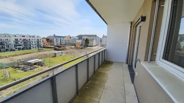 Geräumiger Balkon mit Fliesenboden und weitem Blick über die städtische Umgebung und Baustellen.