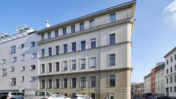 Gebäudeansicht mit moderner Architektur und klaren Linien unter blauem Himmel.