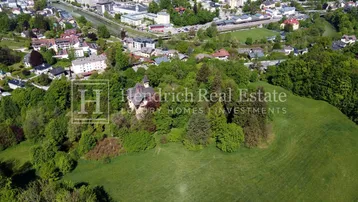 Luftaufnahme der Villa inmitten einer grünen Landschaft mit Blick auf die umliegende Stadt.