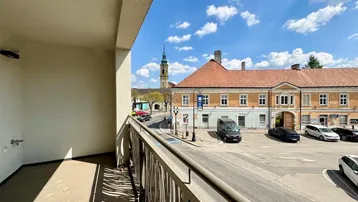 Geräumiger Balkon mit Blick auf die belebte Straße und historische Gebäude im Stadtzentrum.