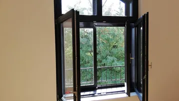 Offenes Rundbogenfenster mit französischem Balkon bietet einen schönen Blick ins Grüne.