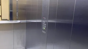 Moderner Aufzug mit Edelstahlverkleidung und Bedienfeld.