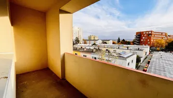 Geräumiger Balkon mit Blick auf die umliegenden Gebäude und den Himmel.