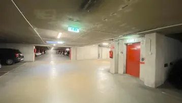 Geräumige Tiefgarage mit ausreichend Parkplätzen, guter Beleuchtung und Notausgang.