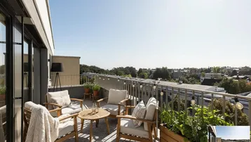 Geräumige Dachterrasse mit bequemen Gartenmöbeln und weitem Blick über die Stadt und die Umgebung.