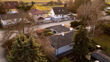 Luftaufnahme eines Einfamilienhauses mit Garten und umliegender Wohnbebauung in ländlicher Umgebung.