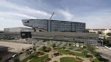 Weitläufige Ansicht eines modernen Bürokomplexes mit markanter Architektur und umliegenden Grünflächen.