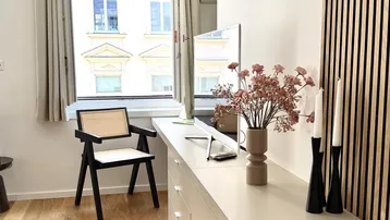 Heller Wohnbereich mit modernem Sideboard, Arbeitsplatz und Blick auf die Stadt.