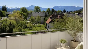 Heller Balkon mit Bergblick und grüner Umgebung, ideal zum Entspannen im Freien.