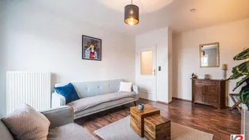 Gemütliches Wohnzimmer mit Holzboden, bequemen Sofas und stilvoller Dekoration.