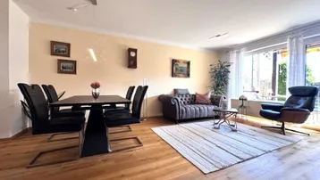 Heller Wohn-Essbereich mit Parkettboden, beiger Wandfarbe und gemütlicher Sitzecke.