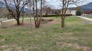 Großes, unbebautes Grundstück mit Bäumen und Blick auf die umliegende Berglandschaft.