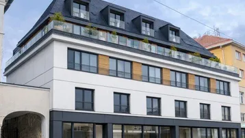 Modernes Gebäude mit weißer und dunkelgrauer Fassade, großen Fenstern und Mansarddach mit Dachterrasse.