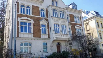 Historisches Stadthaus mit eleganter, verzierter Fassade, großen Fenstern und Mansarddach in gutem Zustand.