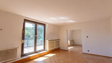 Helles Zimmer mit Parkettboden und Zugang zu einer Terrasse, bereit für die individuelle Gestaltung.