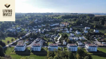 Luftaufnahme einer modernen Wohnsiedlung mit Mehrfamilienhäusern in ländlicher Umgebung.