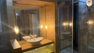 Modernes Badezimmer mit Holzwaschtisch, Aufsatzwaschbecken und großer begehbarer Dusche.