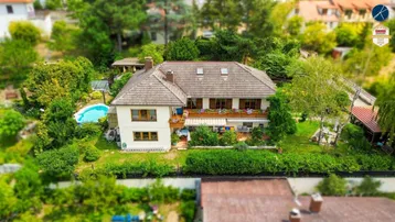 Luftaufnahme eines Hauses mit Garten, Pool und umliegender grüner Landschaft.
