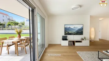 Helles Wohnzimmer mit Holzboden, modernen Möbeln und direktem Zugang zur möblierten Terrasse und Garten.
