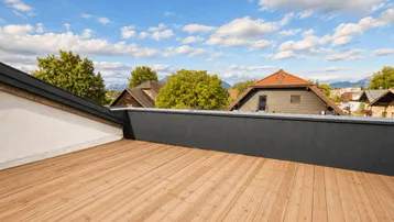Große Dachterrasse mit Lärchenholzboden und weitem Blick über die Umgebung und Berge.