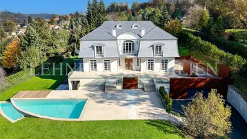 Luxuriöse Villa mit großem Garten, Pool und weitläufiger Terrasse in grüner Umgebung.