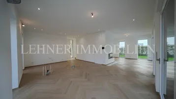 Heller Wohnbereich mit modernem Kamin und Fischgrätparkett, bietet viel Platz und Tageslicht.