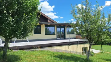Große geflieste Terrasse am Haus mit weitem Blick ins Grüne und auf die Berge.