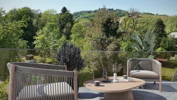Moderne Terrasse mit bequemen Outdoor-Möbeln, Glasgeländer und weitem Blick ins Grüne.