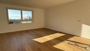 Lichtdurchfluteter Wohnraum mit neuem Holzboden und weitem Blick ins Grüne.