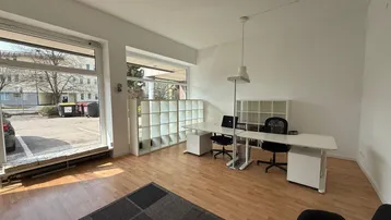 Büroraum mit großen Fenstern, die viel Tageslicht hereinlassen, und modernen Arbeitsplätzen.