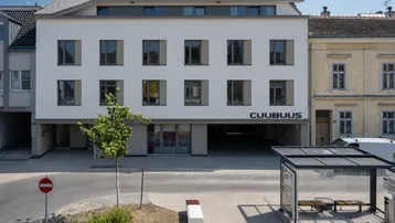 Moderne Wohnanlage mit weißer Fassade und Flachdach in städtischer Umgebung.