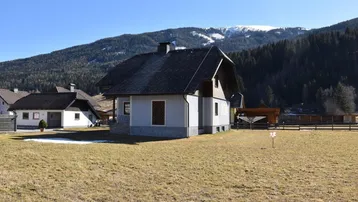 Freistehendes Haus mit Satteldach und weitem Blick auf die umliegende Berglandschaft und Wiesen.