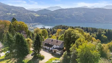 Panoramablick auf das Anwesen mit See- und Bergsicht, umgeben von üppiger Natur.