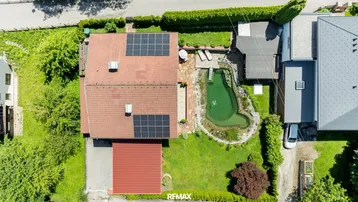 Vogelperspektive des Hauses mit Garten, Naturteich und Photovoltaikanlage auf dem Dach.