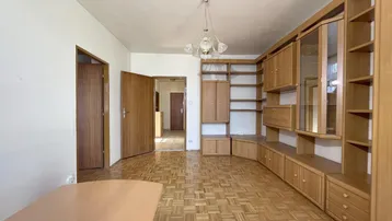 Geräumiges Wohnzimmer mit Holzparkett und großer Schrankwand, hell und einladend.