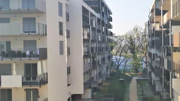 Mehrere moderne Wohngebäude mit Balkonen und einem begrünten Innenhof.