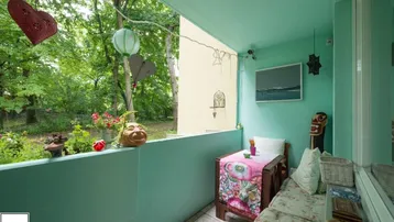 Gemütlicher Balkon mit Blick ins Grüne, dekoriert mit Pflanzen und Sitzgelegenheiten für entspannte Stunden.