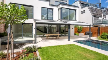 Moderne Villa mit großzügigem Garten, Terrasse und privatem Pool für entspanntes Wohnen im Freien.