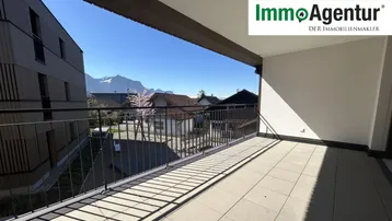 Geräumiger Balkon mit Fliesenboden und weitem Blick auf die umliegende Berglandschaft.