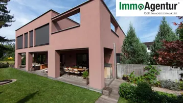 Moderne Villa mit großem Garten und möblierter Terrasse für entspannte Stunden im Freien.