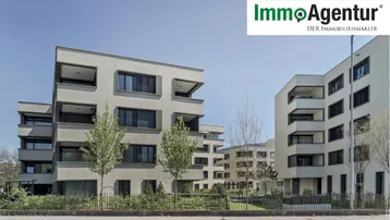 Moderne Wohngebäude mit klaren Linien und Balkonen unter blauem Himmel.