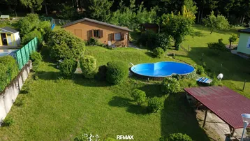 Luftaufnahme des Anwesens mit Garten, Pool und umgebender Natur.