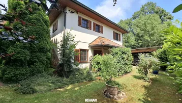 Traditionelles Einfamilienhaus mit gepflegtem Vorgarten und Holzfensterläden.