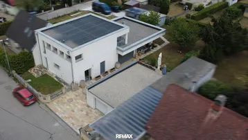 Moderne Wohnhausanlage mit Flachdach und Photovoltaikanlage in einer ruhigen Wohngegend.