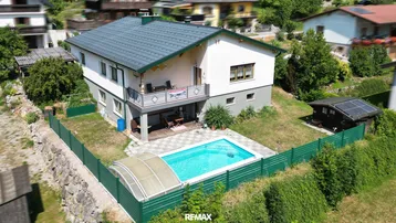 Großzügiges Einfamilienhaus mit privatem Pool, Garten und sonniger Lage in grüner Umgebung.