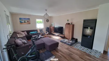 Gemütliches Wohnzimmer mit großem Sofa, modernem Holzofen und Unterhaltungsbereich für entspannte Abende.