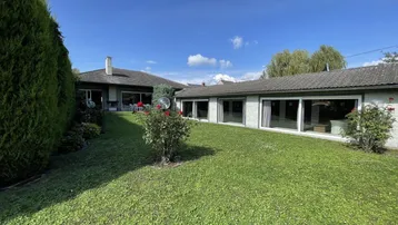 Großer, gepflegter Gartenbereich mit Rasenfläche und Blick auf das Wohnhaus.