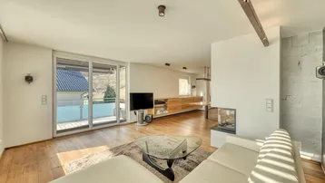 Helles Wohnzimmer mit Holzboden, modernem Kamin und Zugang zu einem Außenbereich.